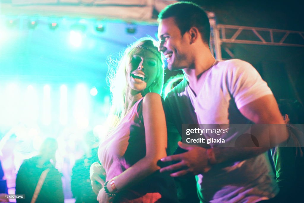 Couple dancing at concert party.