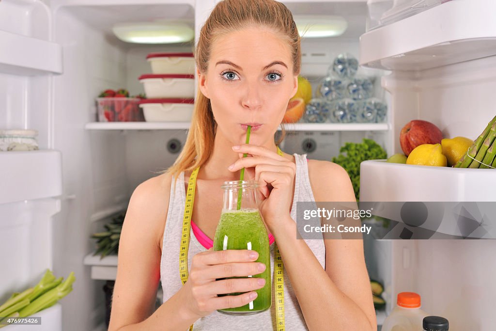 Junge Frau trinken grünen smoothie