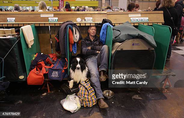 Man sleeps as he sits besides a Border Collie on the first day of Crufts dog show at the NEC on March 6, 2014 in Birmingham, England. Said to be the...