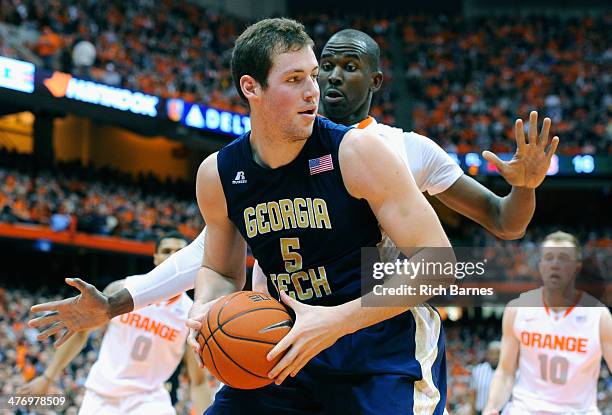 Daniel Miller of the Georgia Tech Yellow Jackets drives to the basket against the defense of Baye Moussa Keita of the Syracuse Orange during the...