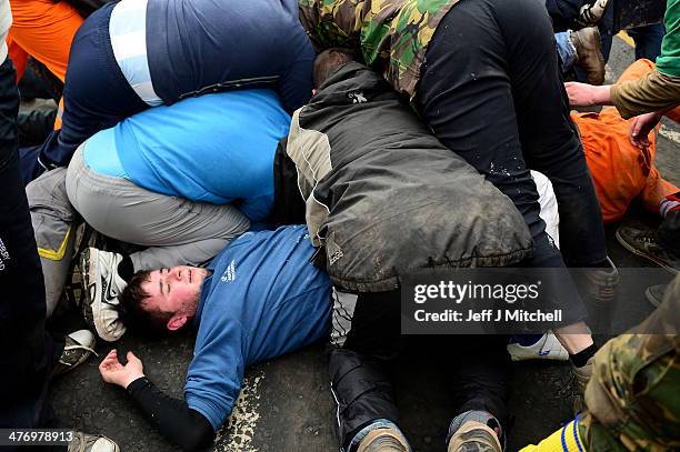 Men tussle for the leather ball during the annual 'Fastern Eve Handba' event in Jedburgh's High Street in the Scottish Borders on March 6, 2014 in...