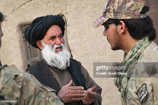 An Afghan interpreter with the U.S. Army's 4th squadron 2d Cavalry Regiment helps to question a villager during a joint patrol with soldiers from the...