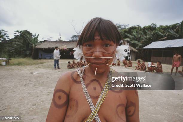 Yanomami woman with pierced nose and cheeks, at a village in the Amazon rainforest of Venezuela, 2001.