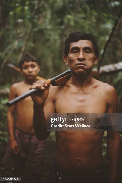 Yanomami man and a boy on a hunting expedition in the Amazon rainforest of Venezuela, 2001.