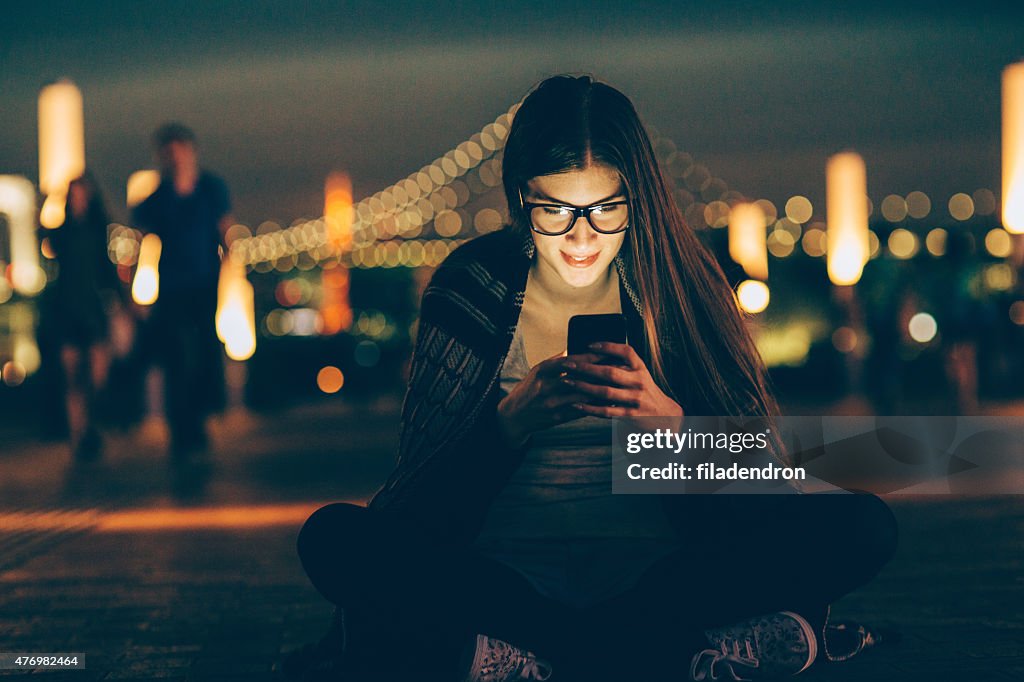 Young nerd woman texting on the phone