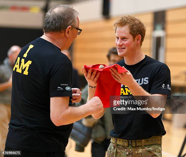 Prince Harry is presented with a baby t-shirt as he attends the launch of the Invictus Games at the Copper Box Arena in the Queen Elizabeth Olympic...