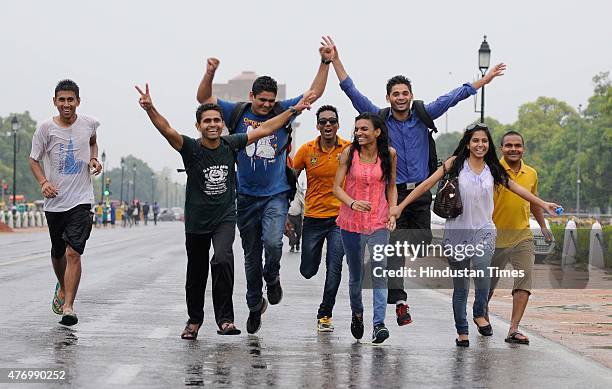 People enjoy the rain after heavy dust storm on June 13, 2015 in New Delhi, India. The change of weather in the national capital has brought in some...