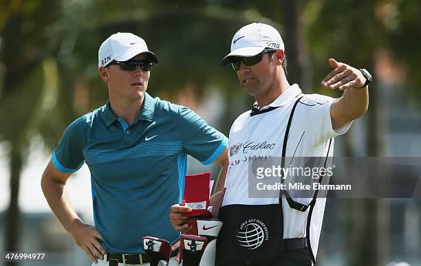 Russell Henley chats with his caddie Adam Hayes during the first round of the World Golf Championships-Cadillac Championship at Trump National Doral...