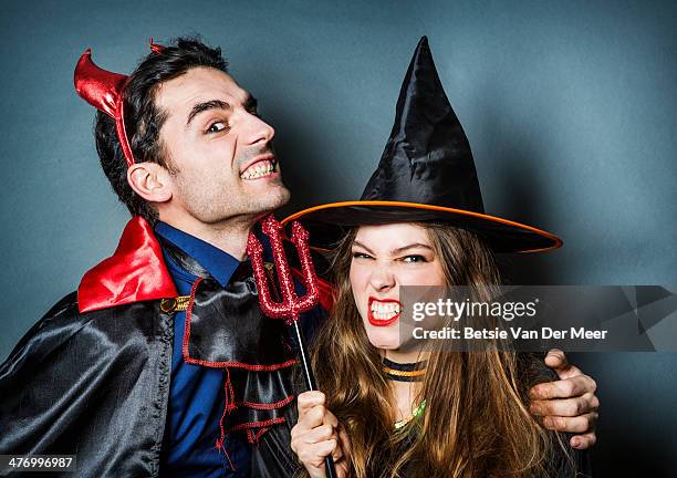 halloween devil and witch pulling faces. - devil woman stock pictures, royalty-free photos & images