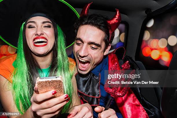 halloween witch and devil laughing in back of car - sombrero de fiesta fotografías e imágenes de stock