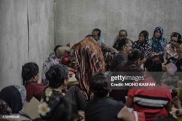 Jupirin Gombur a shaman from the Kadazan-Dusun tribe smokes as she chants slogans during the Monolibabow rituals in Damat, in the district of...
