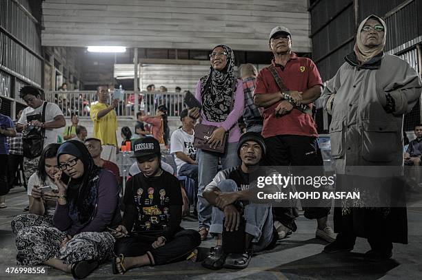 Villagers watch as they attend the Kadazan-Dusun tribe offering for the Monolibabow rituals in Damat, in the district of Tamparuli, in Malaysia's...
