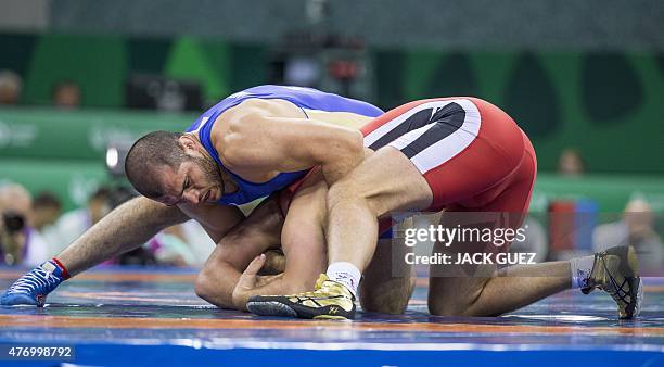 Ukraine's Dimitriy Timchenko wrestles with Russias Islam Magomedov during their mens greco-roman 98kg wrestling final match at the 2015 European...