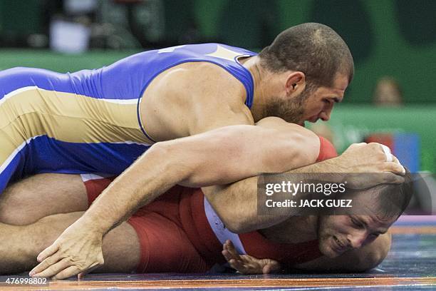 Ukraine's Dimitriy Timchenko wrestles with Russias Islam Magomedov during their mens greco-roman 98kg wrestling final match at the 2015 European...