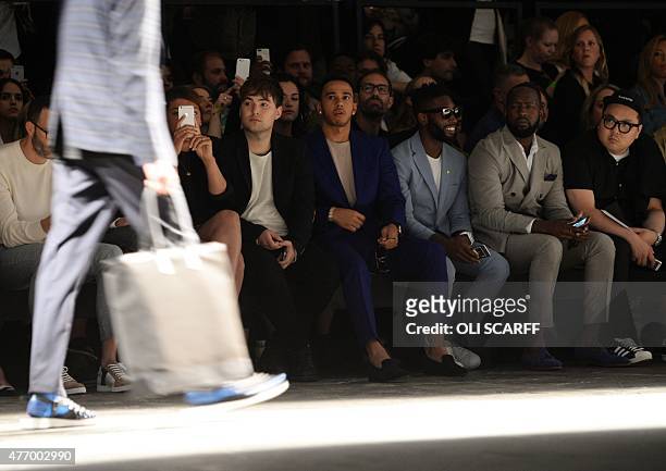 British Formula One racing driver Lewis Hamilton and Sebastian Bailey watch a fashion show by designer Casely-Hayford on the second day of the...