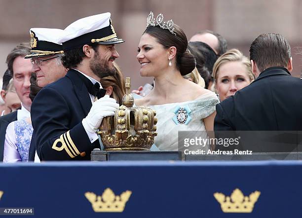 Prince Carl Philip of Sweden places one hand on the crown as he chats with his sister, Crown Princess Victoria of Sweden, after his marriage ceremony...