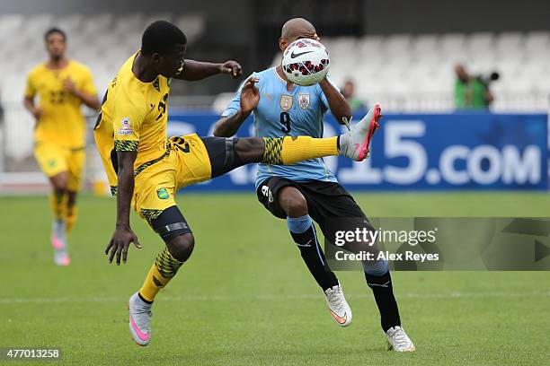 Kemar Lawrence of Jamaica fights for the ball with Diego Rolan of Uruguay during the 2015 Copa America Chile Group B match between Uruguay and...