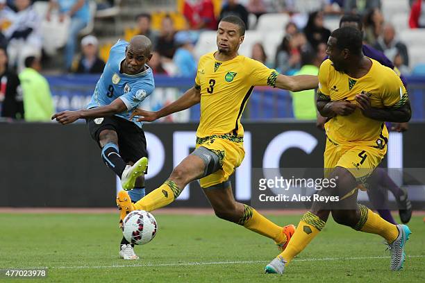 Diego Rolan of Uruguay kicks the ball as Michael Hector of Jamaica tries to stop him during the 2015 Copa America Chile Group B match between Uruguay...