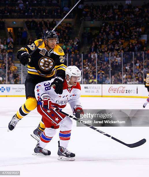 Chris Kelly of the Boston Bruins attempts to jump around Jack Hillen of the Washington Capitals in the first period during the game at TD Garden on...