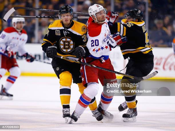 Troy Brouwer of the Washington Capitals is hit by Carl Soderberg and Johnny Boychuk of the Boston Bruins in the second period during the game at TD...