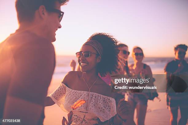 afro mädchen tanzen mit ihrem freund auf einer sunset beachparty - girl beach sunset stock-fotos und bilder