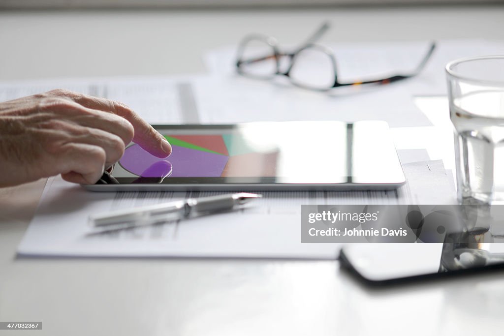 Finger pointing at pie chart on tablet