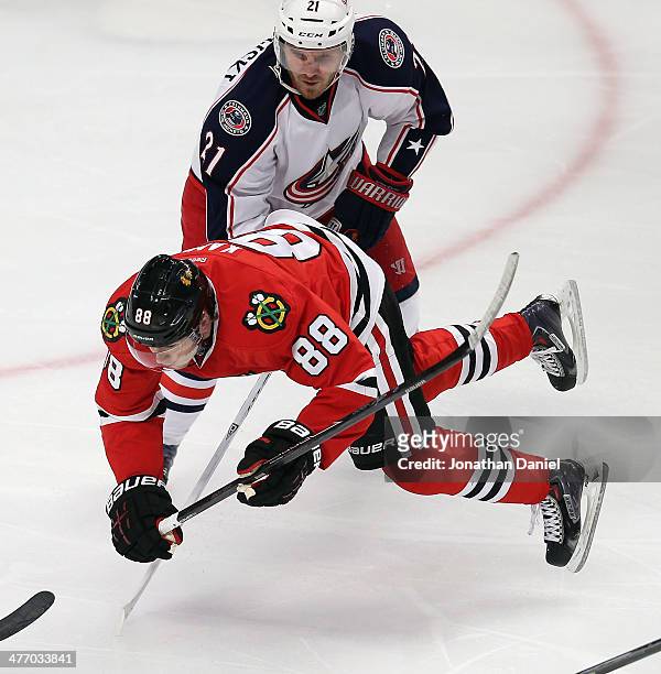Patrick Kane of the Chicago Blackhawks is tripped by James Wisniewski of the Columbus Blue Jackets at the United Center on March 6, 2014 in Chicago,...