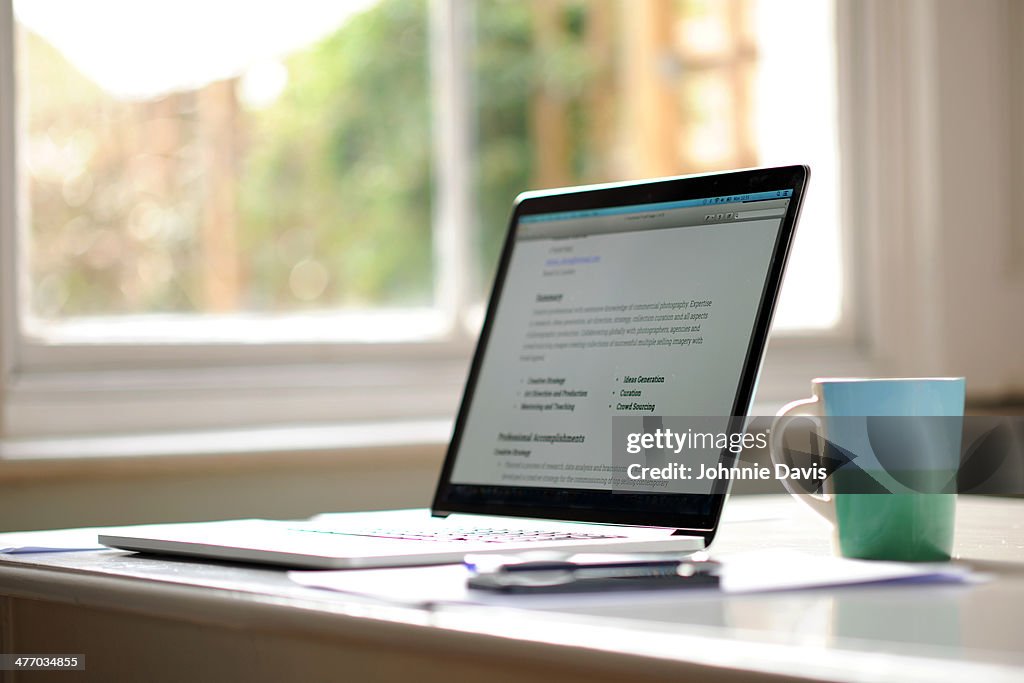 Working from home, laptop with mug by a window