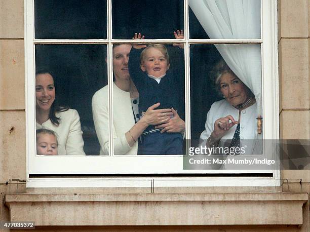 Prince George of Cambridge being held up at a window of Buckingham Palace by his nanny Maria Teresa Turrion Borrallo to watch Trooping the Colour on...
