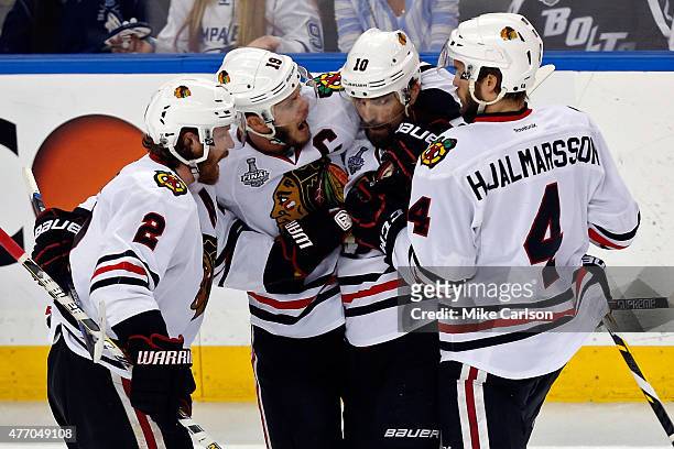 Patrick Sharp of the Chicago Blackhawks celebrates with teammates Niklas Hjalmarsson, Duncan Keith and Jonathan Toews after scoring an empty net goal...