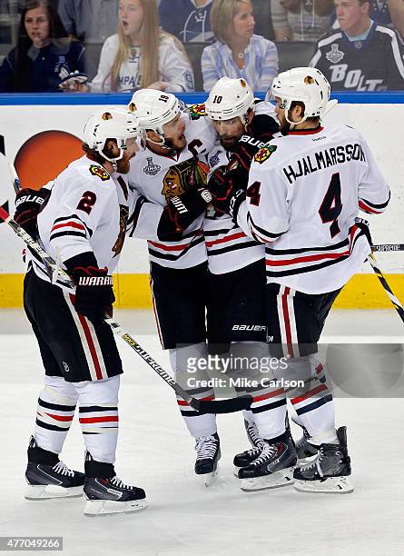 Patrick Sharp of the Chicago Blackhawks celebrates with teammates Niklas Hjalmarsson, Duncan Keith and Jonathan Toews after scoring an empty net goal...