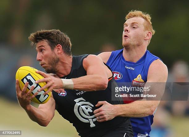Dale Thomas of the Blues is tackled by Adam Cooney of the Bulldogs during the AFL practice match between the Carlton Blues and Western Bulldogs at...