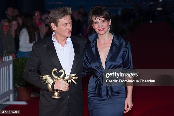 Benoit Magimel poses with actress Juliette Binoche as he awarded best actor during the closing ceremony of the 29th Cabourg Film Festival on June 13,...