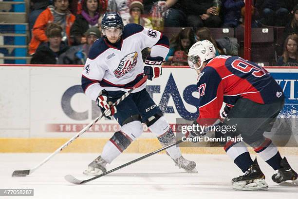 Cody Payne of the Saginaw Spirit moves the puck against Brady Vail of the Windsor Spitfires on March 6, 2014 at the WFCU Centre in Windsor, Ontario,...