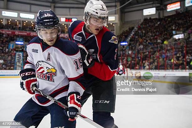 Eric Locke of the Saginaw Spirit battles for the puck against Patrick Sanvido of the Windsor Spitfires on March 6, 2014 at the WFCU Centre in...