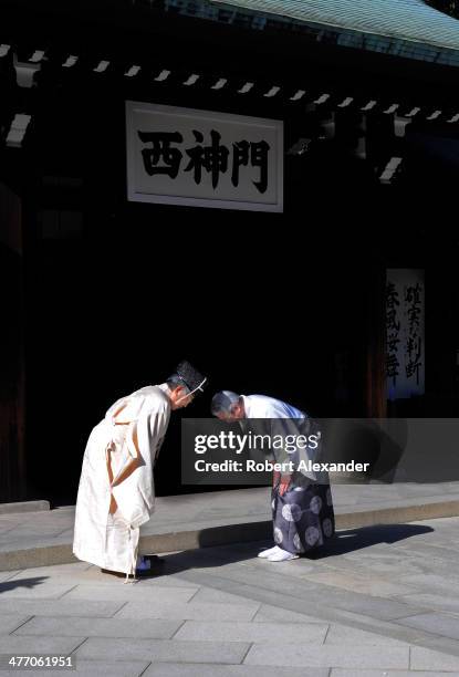 Shinto priest and a shrine official bow to each other during a ceremony at the Meiji-Jingu shrine in the Harajuku district of Tokyo. The shrine and...