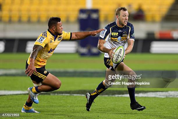 Jesse Mogg of the Brumbies evades the defence of Alapati Leiua of the Hurricanes during the round four Super Rugby match between the Hurricanes and...