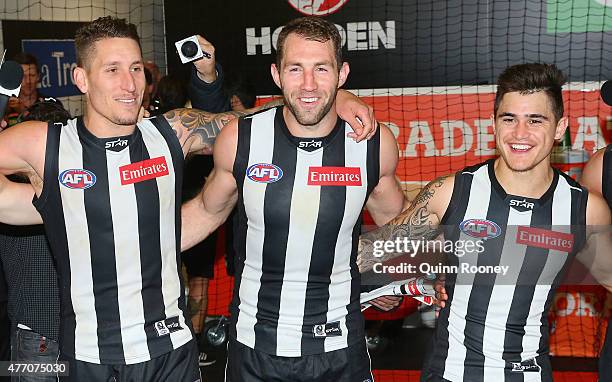 Jesse White, Travis Cloke and Marley Williams of the Magpies sing the song in the rooms after winning the round 11 AFL match between the Collingwood...