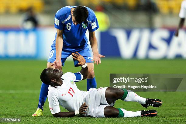Akramjon Komilov of Uzbekistan appeals to Roger Gomis of Senegal after going down injured during the FIFA U-20 World Cup New Zealand 2015...