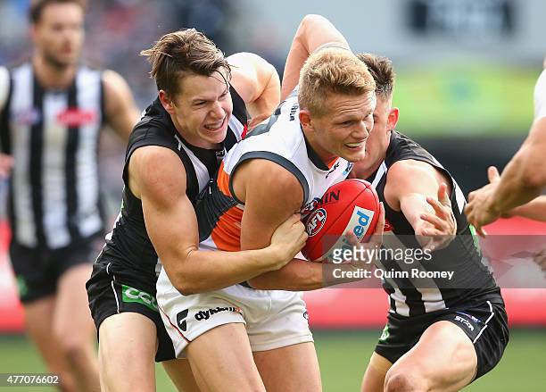Adam Treloar of the Giants is tackled by Tom Langdon of the Magpies during the round 11 AFL match between the Collingwood Magpies and the Greater...