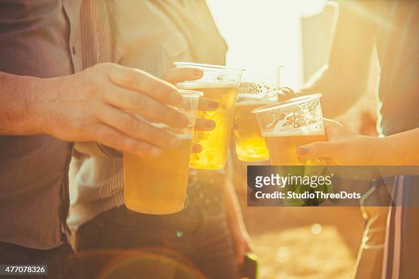freunden anstoßen mit bier - sunlight through drink glass stock-fotos und bilder