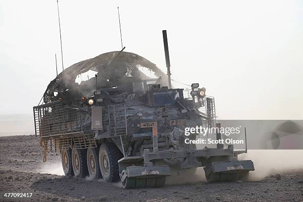 Stryker vehicle from 4th Squadron 2d Cavalry Regiment kicks up dust as it moves across the desert following a live-fire exercise on March 6, 2014...