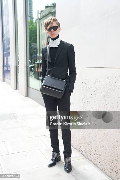 Fashion designer Mikko Puttonen wears a Turo Tailor suit, Jill Sander shoes a Givenchy bag, and Mikko Puttonen collar on day 2 of London Collections:...