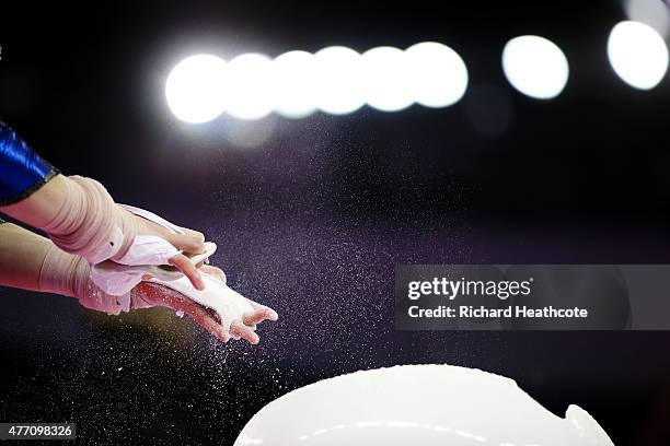 Competitor chalks her hands prior to competing on the uneven bars in the Women's Team Final and Individual Qualification during day two of the Baku...