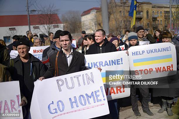 Demonstrators hold placards reading "Putin go home !" and "Help Ukraine ! Stop war !" during an anti-war rally in front of the Russian embassy in...