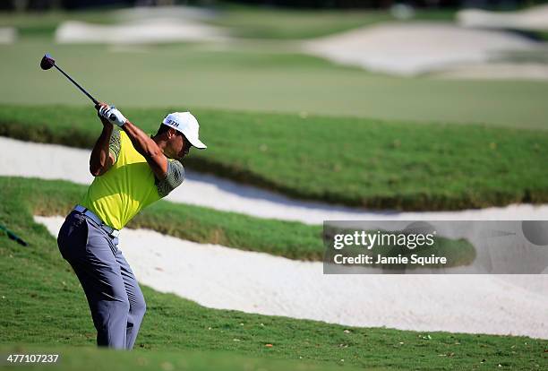 Tiger Woods hits a shot on the 12th hole during the weather-delayed first round of the World Golf Championships-Cadillac Championship at Trump...