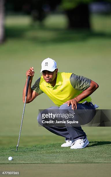 Tiger Woods lines up a putt on the 11th hole during the weather-delayed first round of the World Golf Championships-Cadillac Championship at Trump...