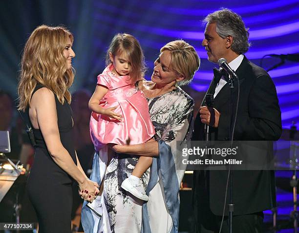 Singer Celine Dion, Andrea Bocelli's daughter Virginia Bocelli, held by actress Sharon Stone, and honoree Andrea Bocelli appear onstage after Dion...