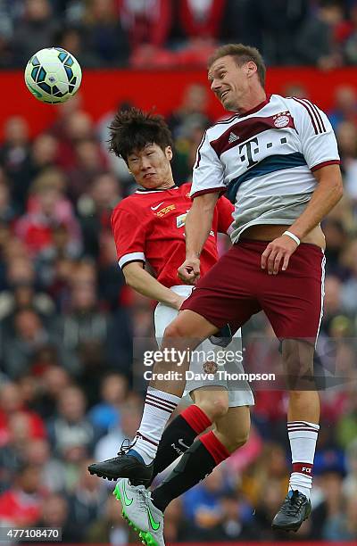 Alexander Zickler of Bayern Munich All Stars wins the ball ahead of Ji-sung Park of Manchester United Legends during the Manchester United Foundation...