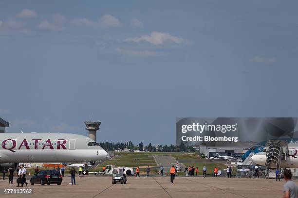 An Airbus A350 aircraft, operated by Qatar Airways Ltd., left, stands on the taxiway during preparations ahead of opening at the 51st International...